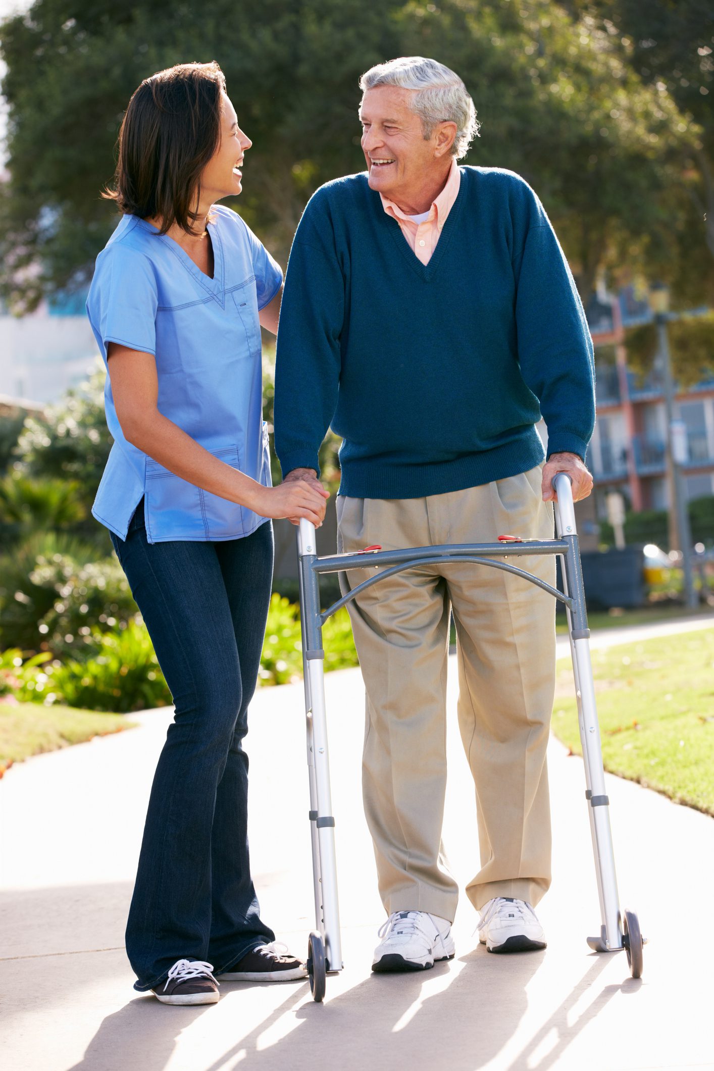 Aged care helping senior man with walking frame